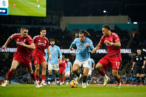 EPL 2024-25: Man City's Jack Grealish, centre, challenges for the ball with Nottingham Forest's Eric da Silva Moreira