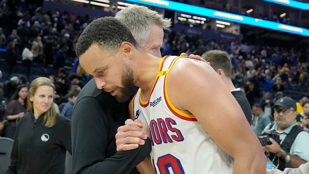 Golden State Warriors guard Stephen Curry hugs head coach Steve Kerr after a victory against the Minnesota Timberwolves in an NBA basketball game in San Francisco. - AP Photo/Tony Avelar