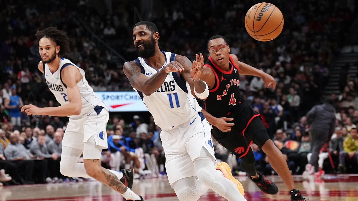 Nathan Denette/The Canadian Press via AP : Dallas Mavericks' Kyrie Irving (11) passes the ball against the Toronto Raptors during second-half NBA basketball game action in Toronto.