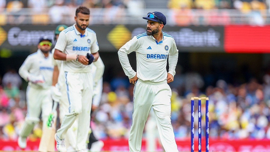 AP : Virat Kohli walks back to his fielding position during play on day one of the third Test between India and Australia at the Gabba in Brisbane.