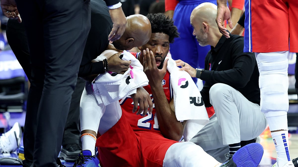 Trainers tend to Joel Embiid #21 of the Philadelphia 76ers during the first half against the Indiana Pacers at the Wells Fargo Center on December 13, 2024 in Philadelphia, Pennsylvania.