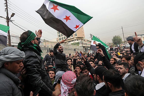 Photo by Safin HAMID / AFP via Getty images  : Opposition flag in Arbil, the capital of Iraq's northern autonomous Kurdish region, on December 8, 2024, as they celebrate the capture of the capital Damascus by rebel forces.