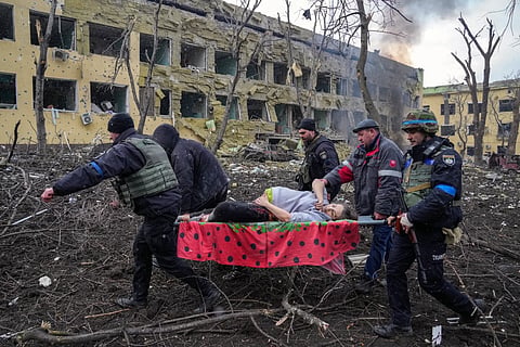 Ukrainian emergency workers carry an injured pregnant woman outside of a bombed maternity hospital in Mariupol, Ukraine, March 9, 2022 |