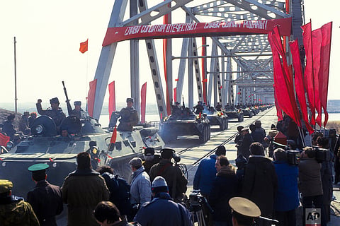 Soviet Army soldiers wave their hands as their unit crosses a bridge on the border between Afghanistan and then Soviet Uzbekistan near the Uzbek town of Termez, Uzbekistan on Feb. 15, 1989 |