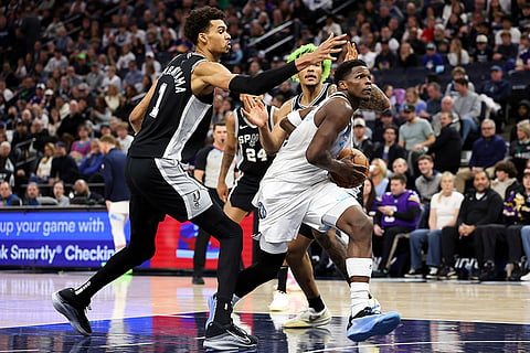 NBA 2024-25: Timberwolves guard Anthony Edwards, middle, drives toward the basket 