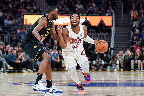NBA 2024-25: Cavaliers guard Donovan Mitchell, right, moves the ball