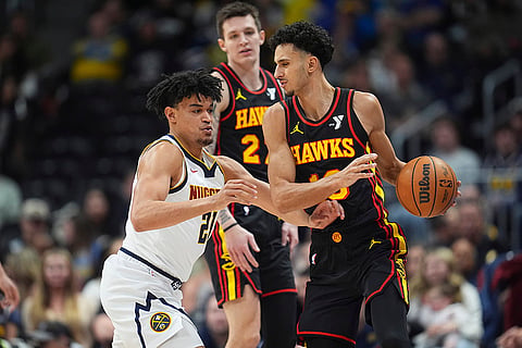NBA 2024-25: Hawks forward Zaccharie Risacher, right, looks to pass the ball 