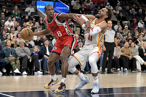 NBA 2024-25: Clippers guard Kris Dunn, left, drives past Hawks guard Trae Young 