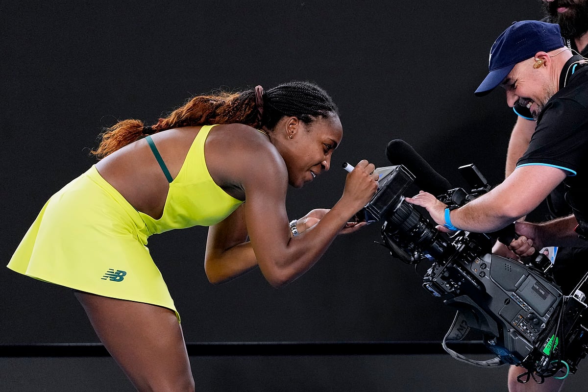  (AP Photo/Vincent Thian) : Coco Gauff of the U.S. autographs a tv camera screen after defeating Jodie Burrage of Britain in their second round match at the Australian Open tennis championship in Melbourne, Australia, Wednesday, Jan. 15, 2025.