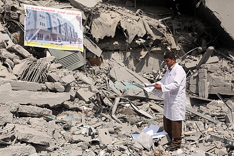 Palestinian doctor inspects devastation the headquarters of El-Wafa rehabilitation hospital