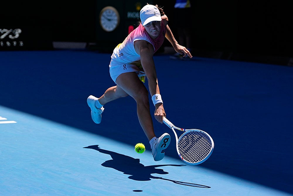 | Photo: AP/Vincent Thian : Australian Open 2025: Iga Swiatek plays a backhand return to Emma Navarro
