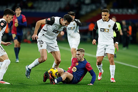 La Liga 2024-25: Barcelona's Fermin Lopez and Valencia's Cesar Tarrega challenge for the ball