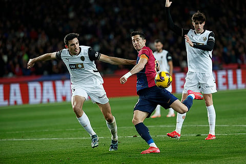 La Liga 2024-25: Valencia's Cesar Tarrega and Barcelona's Robert Lewandowski challenge for the ball