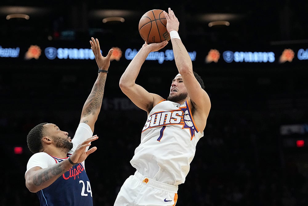 | Photo: AP/Ross D. Franklin : NBA 2024-25: Suns guard Devin Booker (1) shoots over Clippers guard Norman Powell 