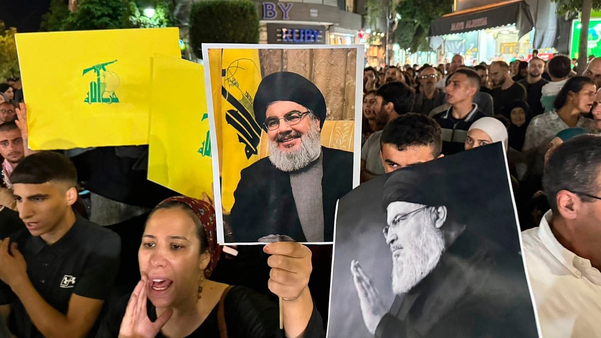 AP : Palestinian protesters carry Hezbollah flags and posters with a picture of Hezbollah leader Sayyed Hassan Nasrallah during a rally in support of Hezbollah, in the West Bank city of Ramallah Saturday, Sept. 28, 2024
