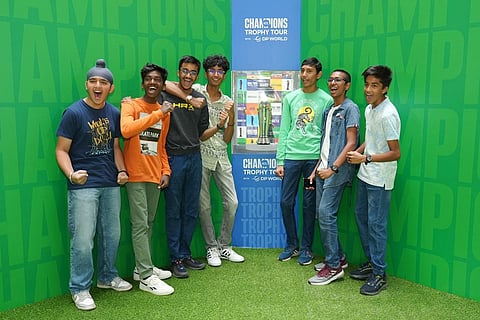Fans pose with the trophy of ICC Men’s Champions Trophy 2025 during Trophy Tour with DP World in India