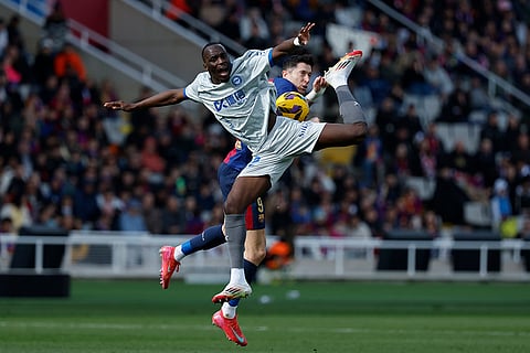 La Liga 2024-25: Alaves' Moussa Diarra and Barcelona's Robert Lewandowski challenge for the ball 