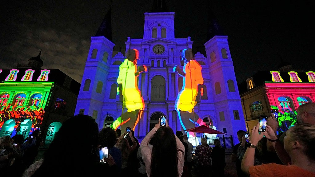 People watch a laser light show projected onto St. Louis Cathedral in the French Quarter, as part of the festivities leading up to Super Bowl. - AP