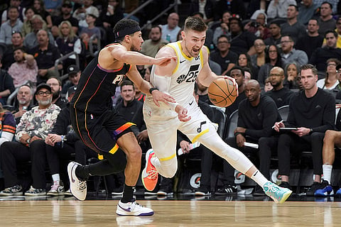 NBA 2024-25: Jazz center Micah Potter (25) drives on Suns guard Devin Booker 