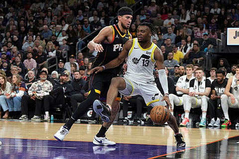 NBA 2024-25: Jazz guard Isaiah Collier (13) shields the ball from Suns guard Devin Booker