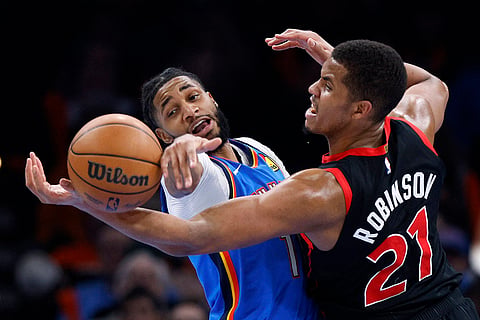 NBA 2024-25: Thunder guard Isaiah Joe and Raptors center Orlando Robinson (21) try to grab the ball 