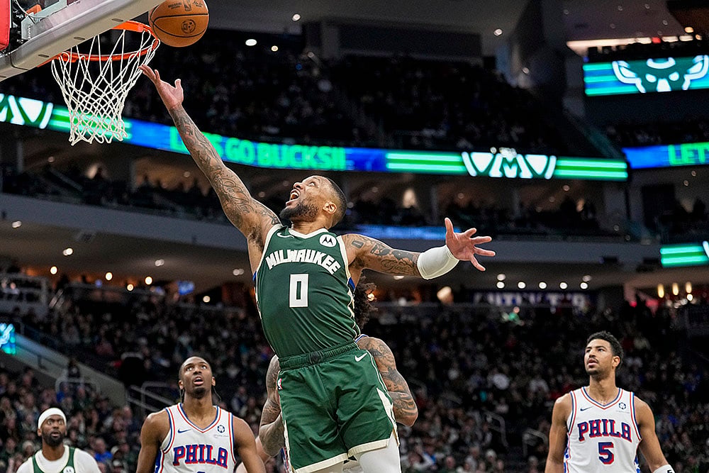 | Photo: AP/Andy Manis : NBA 2024-25: Bucks' Damian Lillard (0) shoots against the 76ers 