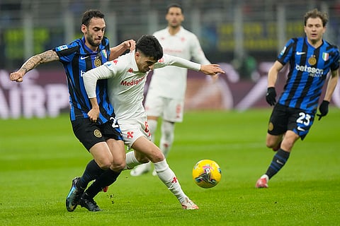 Serie A: Inter Milan's Hakan Calhanoglu challenges for the ball with Fiorentina's Fabiano Parisi