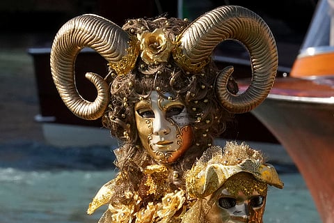 Venice Carnival 2025: A masked woman sits on a gondola