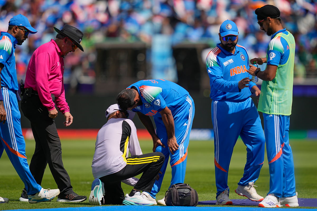 India's Mohammed Shami, centre, is attended by the team physio during the ICC Champions Trophy cricket match between India and Pakistan at Dubai International Cricket Stadium, United Arab Emirates, Sunday, Feb. 23, 2025.