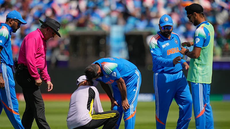 Indias Mohammed Shami, centre, is attended by the team physio. AP Photo