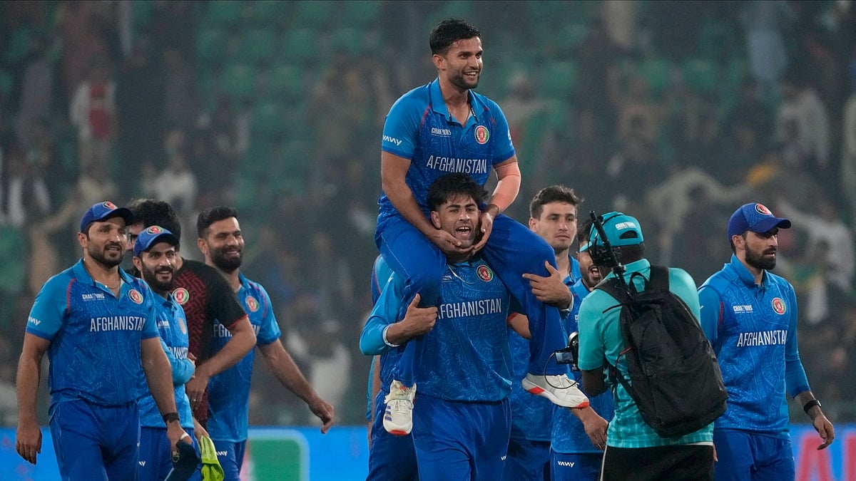 AP Photo/K.M. Chaudary : Afghanistan's Azmatullah Omarzai, center on shoulder, and teammates celebrate after winning the ICC Champions Trophy cricket match against England, in Lahore.
