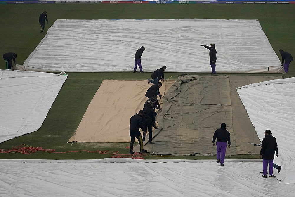 | Photo: AP/Anjum Naveed : ICC Champions Trophy, PAK vs BAN: Groundsmen cover the pitch and other area due to rain  
