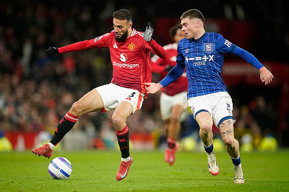 | Photo: AP/Dave Thompson : EPL 2024-25: Manchester United's Noussair Mazraoui duels for the ball with Ipswich Town's Leif Davis