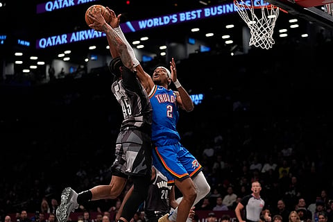 NBA 2024-25: Thunder's Shai Gilgeous-Alexander (2) defends a shot by Nets' Keon Johnson 