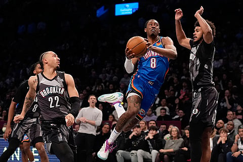 NBA 2024-25: Thunder's Jalen Williams (8) drives past Nets' Cameron Johnson and Jalen Wilson