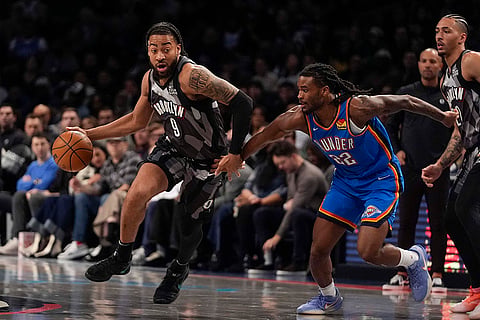 NBA 2024-25: Nets' Trendon Watford (9) drives past Thunder's Cason Wallace