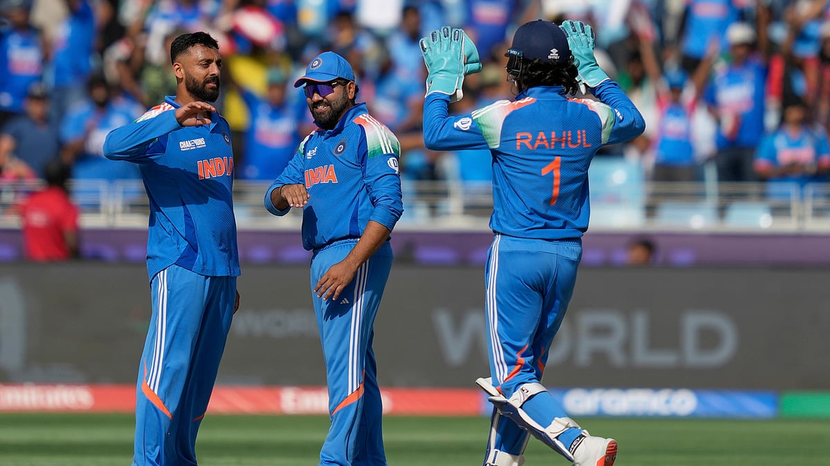 AP Photo/Altaf Qadri : India's Varun Chakravarthy, left, celebrates with teammates after the dismissal of New Zealand's Glenn Phillips during the ICC Champions Trophy final cricket match between India and New Zealand at Dubai International Cricket Stadium in Dubai.