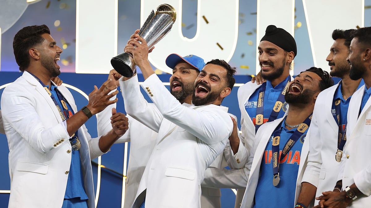 AP Photo/Christopher Pike : India's Virat Kohli and teammates celebrate with the winners trophy on the podium after defeating New Zealand in the final cricket match of the ICC Champions Trophy at Dubai International Cricket Stadium in Dubai.