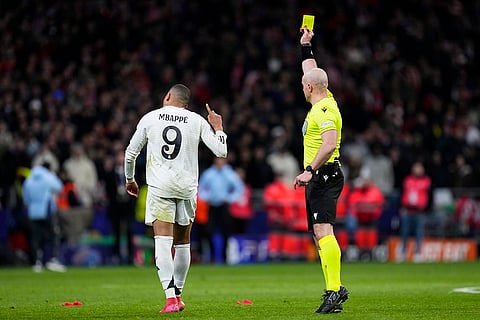 UCL 2024-25, Atletico Madrid and Real Madrid: Referee Szymon Marciniak shows a yellow card to Real Madrid's Kylian Mbappe 