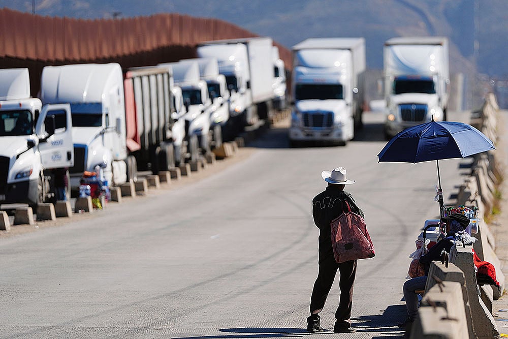 The Impact: A man sells peanuts to truck drivers at the US border in Tijuana, Mexico, as tariffs against Mexico go into effect - | Photo: AP
