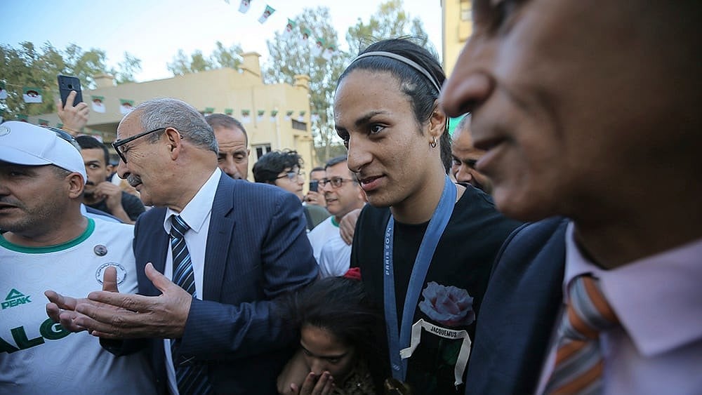 | Photo: AP/Anis Belghoul : Algeria's boxer Imane Khelif smiles as she arrives home
