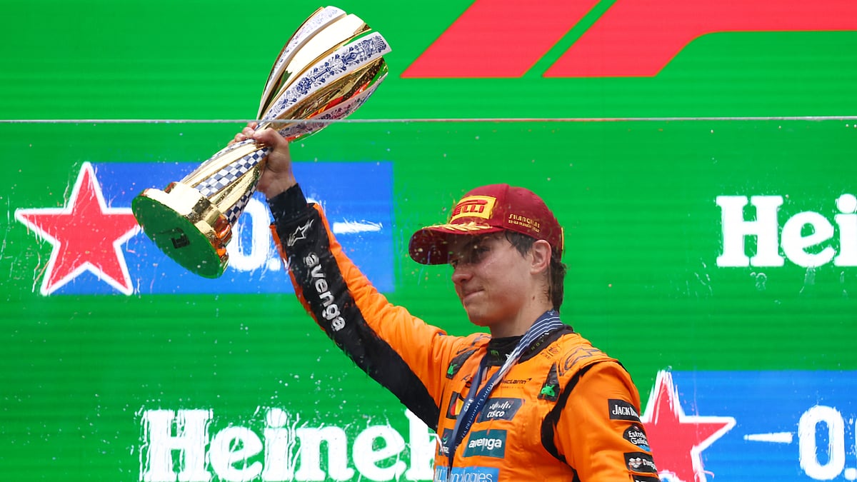 Oscar Piastri hoists the Chinese Grand Prix trophy aloft.