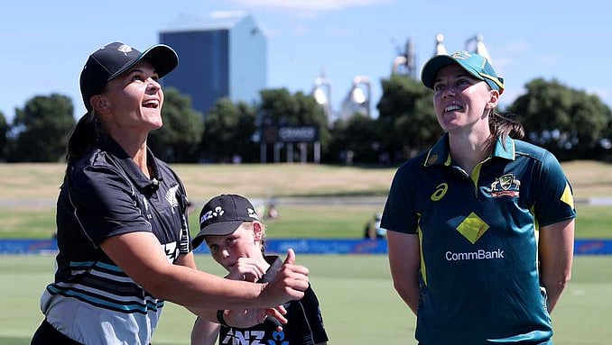 X/cricketcomau : NZ-W skipper Suzie Bates flips the coin as AUS-W captain Tahlia McGrath watches on.