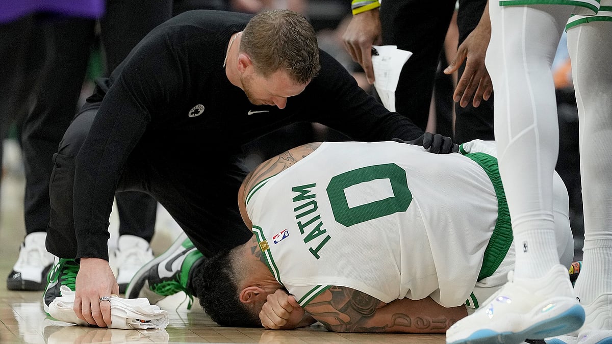 A Boston Celtics trainer attends to an injured Jayson Tatum in a game against the Sacramento Kings on March 24, 2025.