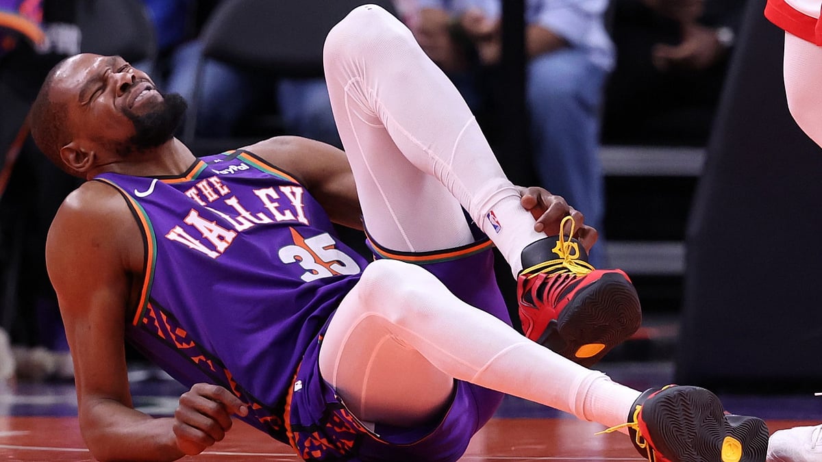 Phoenix Suns forward Kevin Durant grabs his injured ankle in a game vs. the Houston Rockets on March 30, 2025.