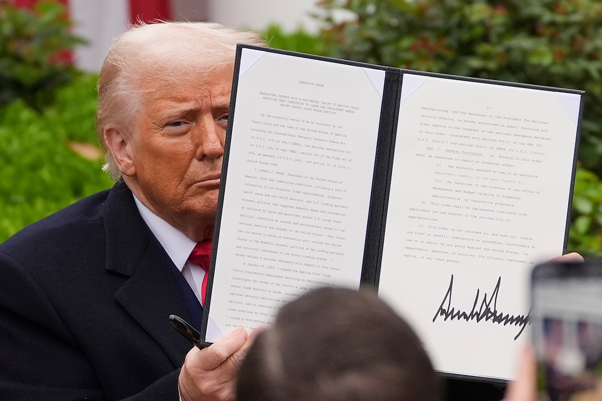 President Donald Trump holds a signed executive order to announce new tariffs in the White House. - AP Photo