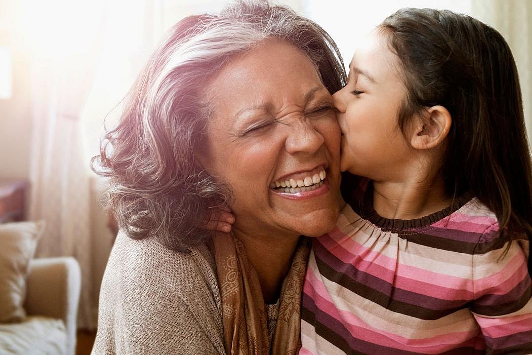 A child kissing its grandmother