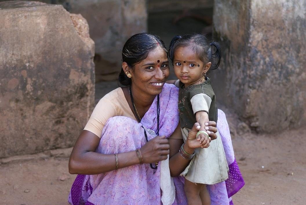 An Indian mother holding her daughters arm