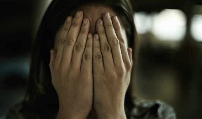 A woman hiding her face with her hands