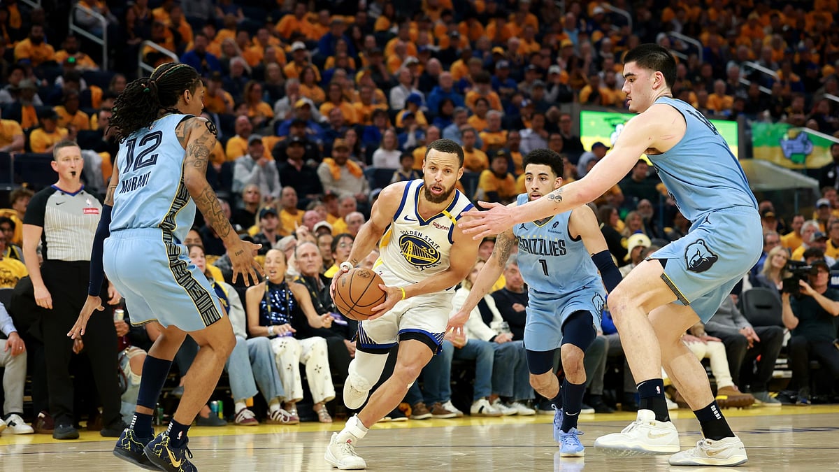 Stephen Curry #30 of the Golden State Warriors is guarded by Ja Morant #12, Scotty Pippen Jr. #1 and Zach Edey #14 of the Memphis Grizzlies in the first half of the NBA play-in tournament game at Chase Center on April 15, 2025 in San Francisco, California. - null